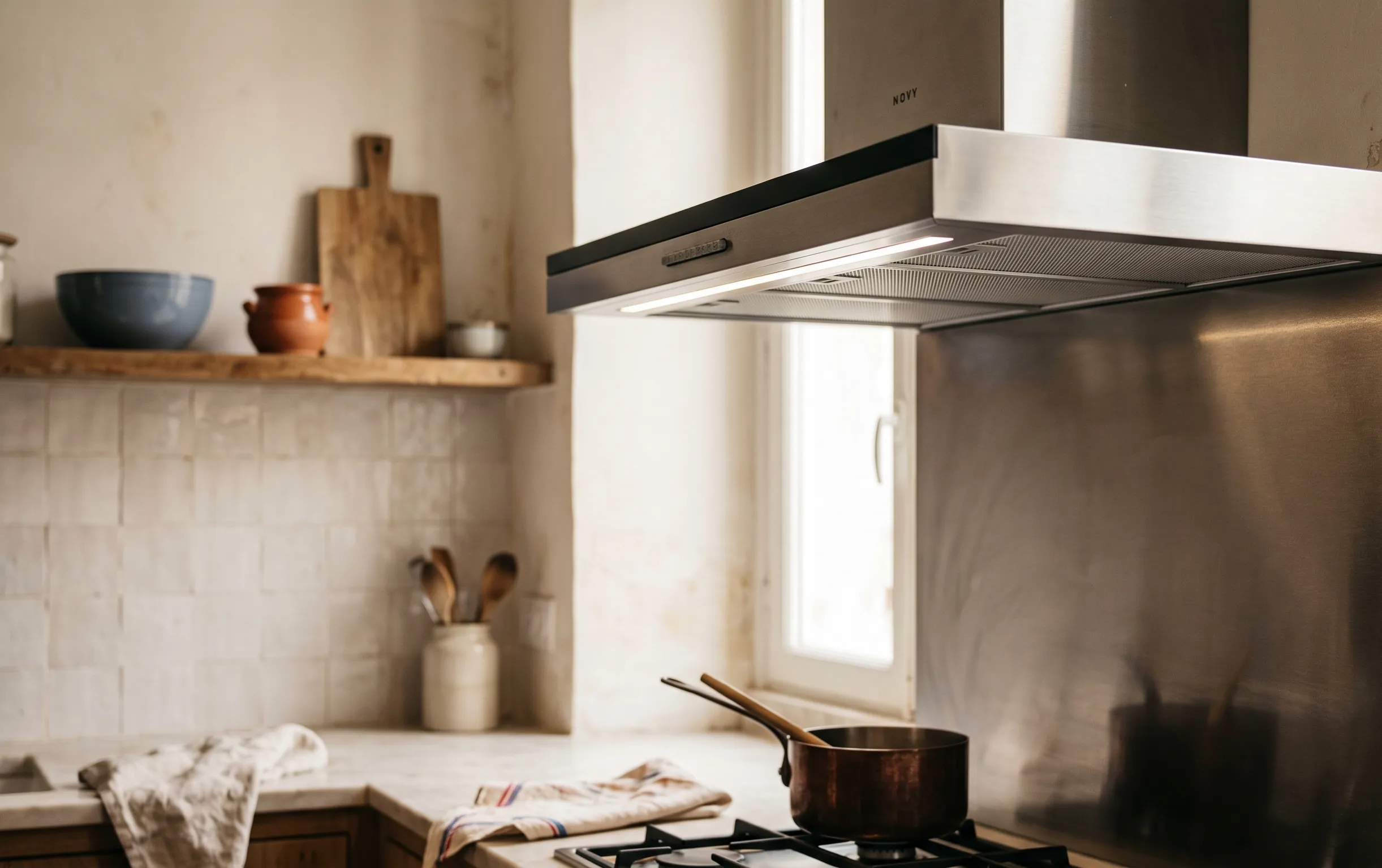 hotte moteur déporté : Gros plan sur les finitions élégantes d'une hotte de cuisine intégrée dans un espace de vie lumineux